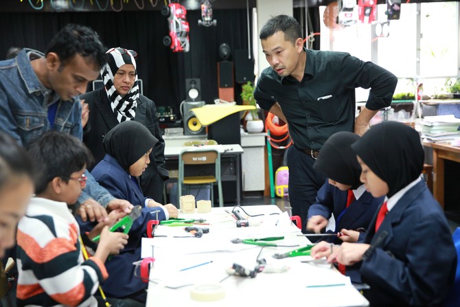 王华湘中学老师向马来西亚师生展示学校STEM教育，包括机械人、实作设计、遥控车，以及「空气炮」科学实验