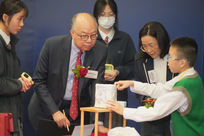 學生向評審陳帆 GBS太平紳士(左二)及鄭慕賢博士(右二)講解自己設計的創新發明作品理念